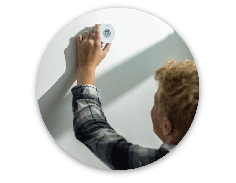 Person adjusting Flair Puck on wall by rotating bezel to set room temperature without a smartphone.